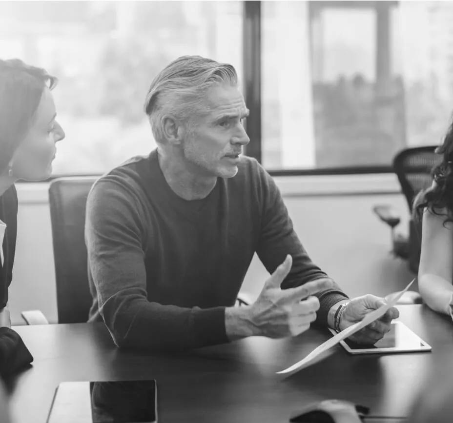 A man sits discusses a topic in a meeting with colleagues