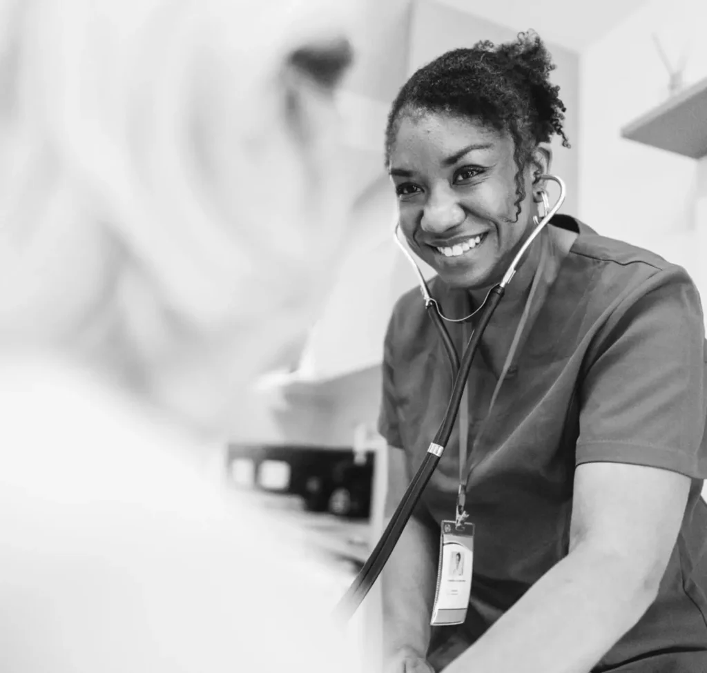 A medical professional smiles at a patient.