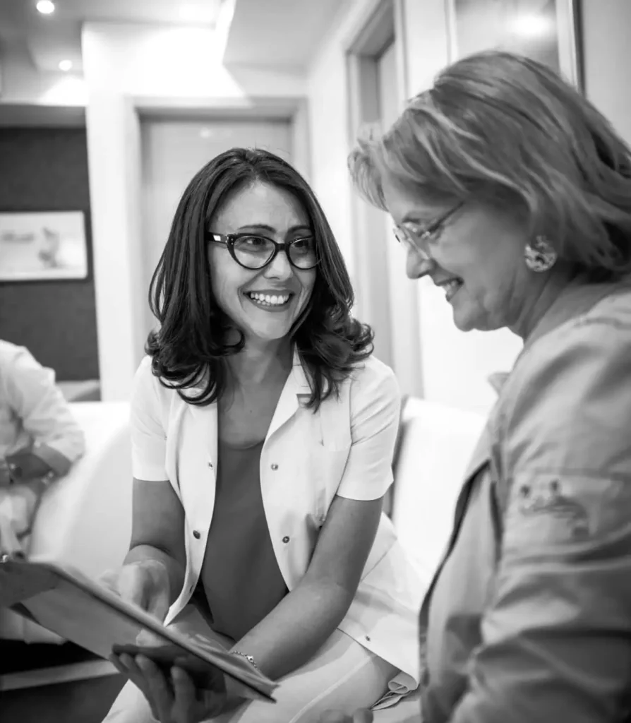 Two colleagues in discussion while looking at a tablet.